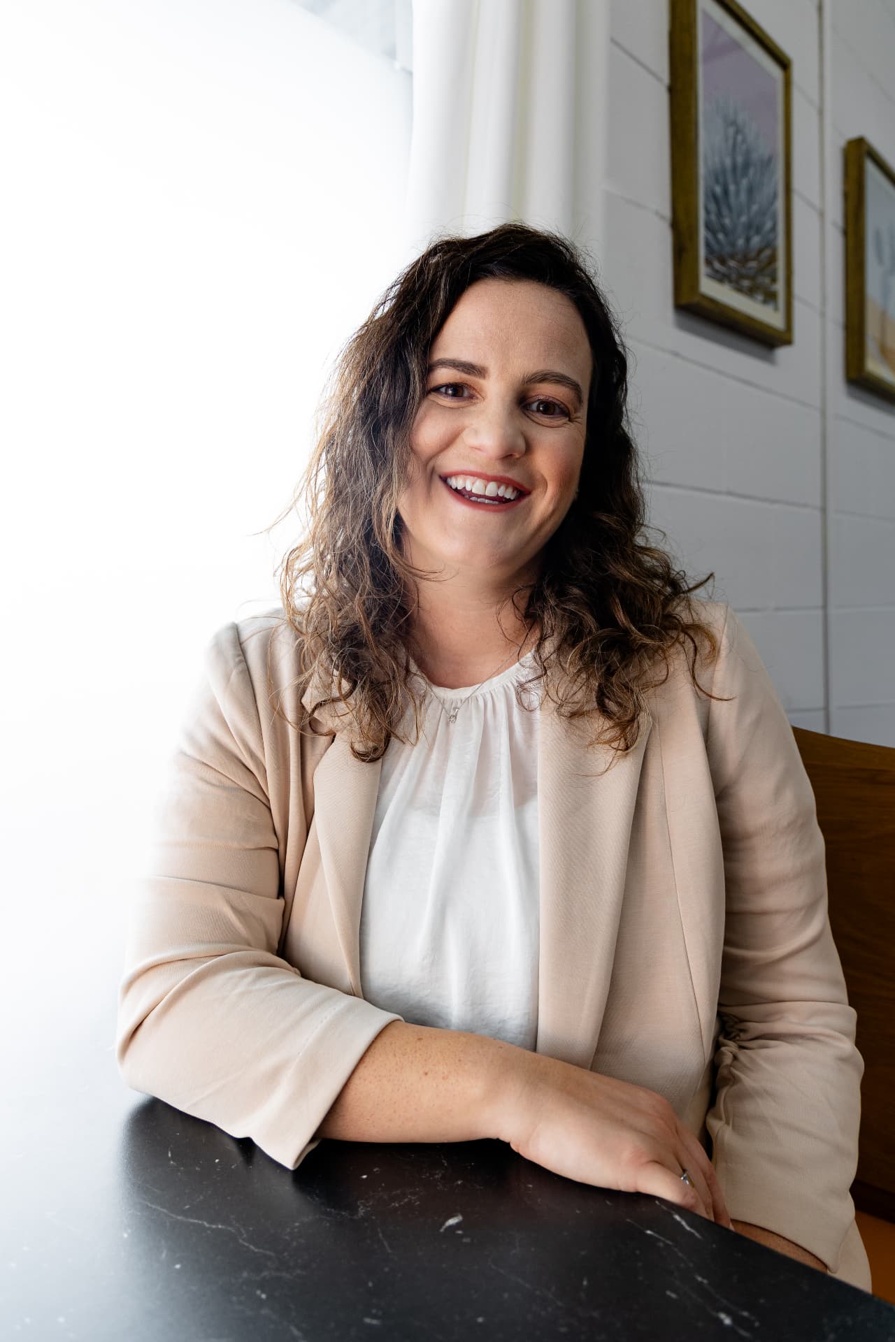 Monica Giannobile smiling at a table by a bright window